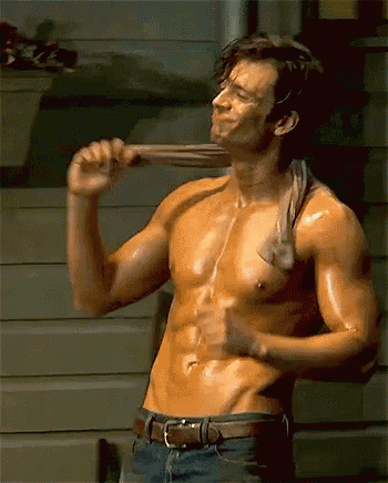 a shirtless man with a towel around his neck is holding a bat .