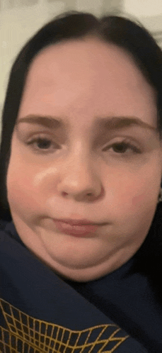 a close up of a woman 's face wearing a blue sweatshirt