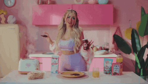 a woman in a pink kitchen holds a piece of chocolate and a jar of jam