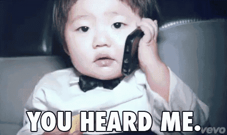 a baby wearing a bow tie talking on a cell phone with the words you heard me