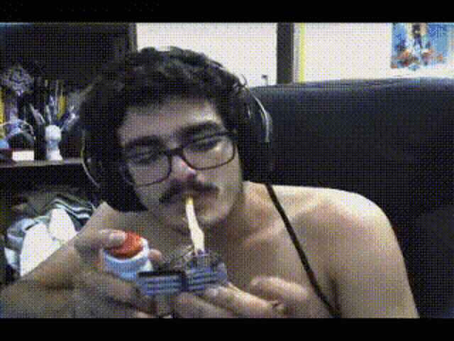 a man without a shirt is lighting a cigarette with a lighter