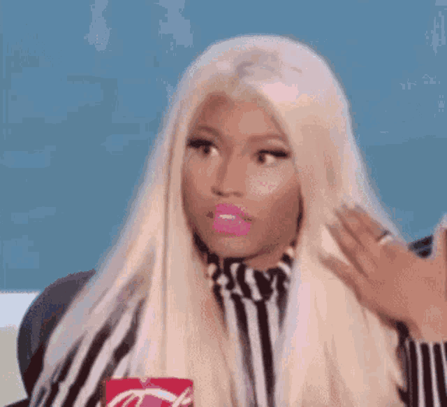 a woman with blonde hair and pink lipstick is holding a coca cola can .