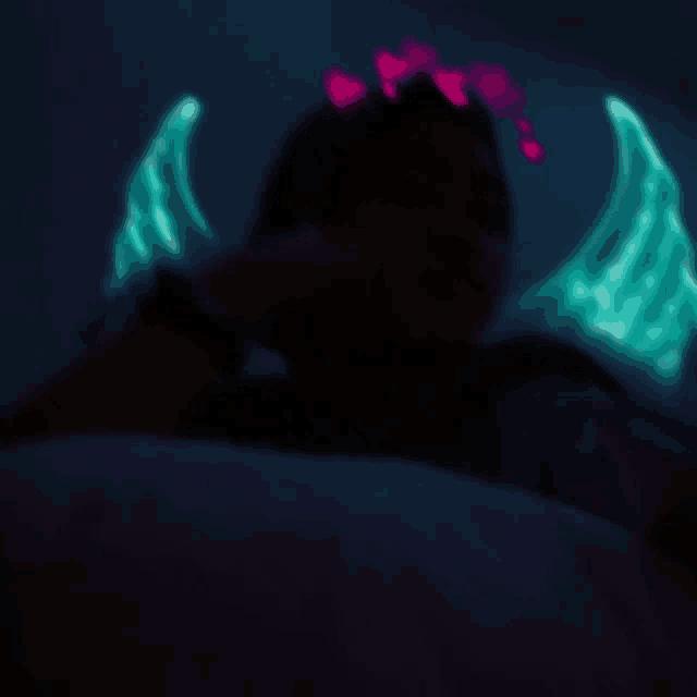 a blurry photo of a person with glowing wings and hearts on their head