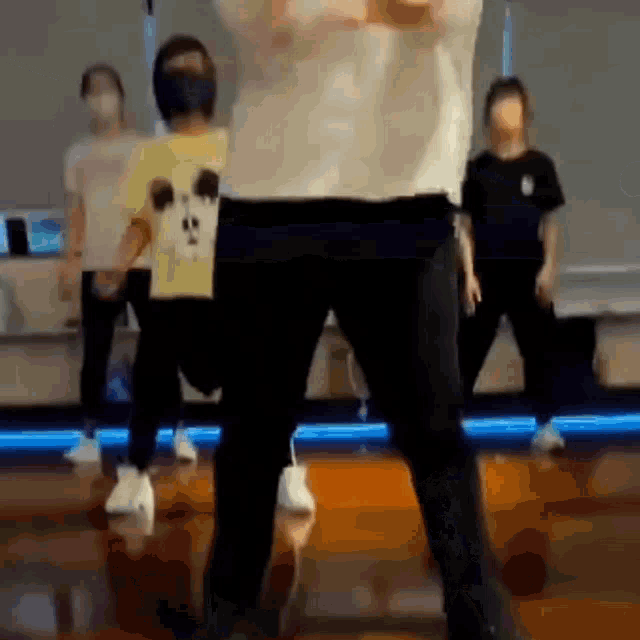 a group of people are dancing together in a dance studio while wearing face masks .