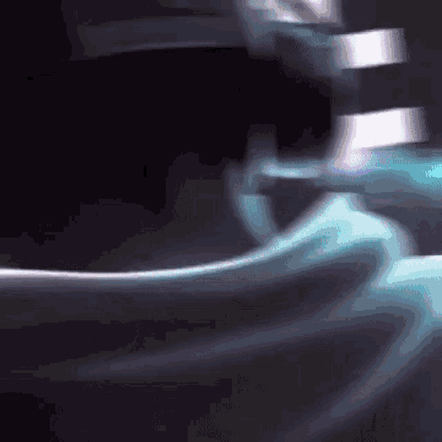 a close up of a person 's face with a blurry background and a blue light coming out of it .