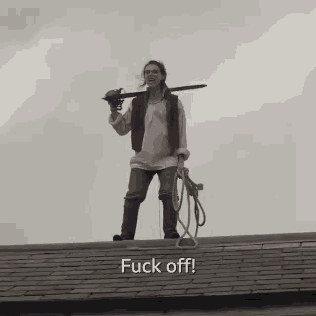 a woman standing on a roof holding a sword and a rope with the words fuck off written below her