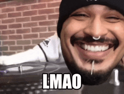 a man with a beard and a nose ring is smiling with the word lmao above his face .