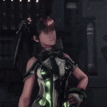 a woman in a green and white costume is standing with her hands on her hips in a dark room .