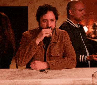 a man sitting at a bar drinking a glass of beer