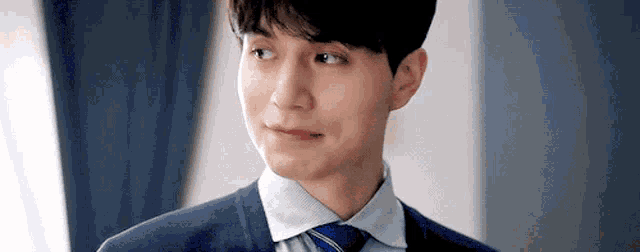 a close up of a man in a suit and tie making a face .