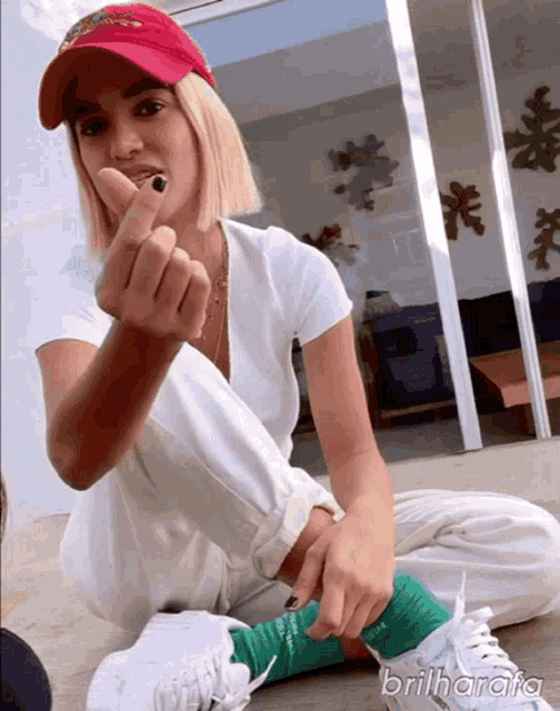 a woman wearing a red hat and green socks sitting on the floor