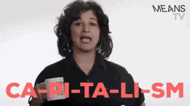 a woman is holding a cup with the words ca-pi-ta-li-sm written on it