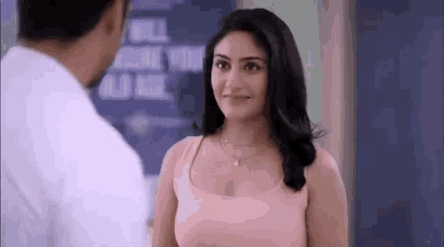 a man and a woman are standing next to each other and looking at each other .