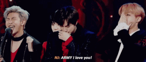 a group of young men are standing next to each other on a stage and one of them is saying `` army i love you ''