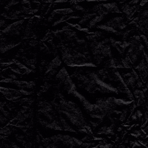 a crumpled piece of black paper with a purple circle in the middle
