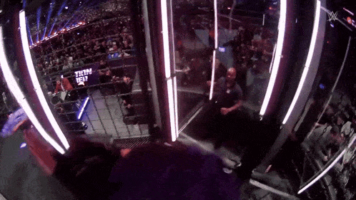 a crowd watching a wrestling match with a sign that says ' tna ' on it