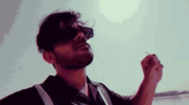 a man wearing sunglasses and a safety vest is smoking a cigarette
