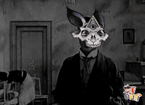 a black and white photo of a man with a skull mask on his head