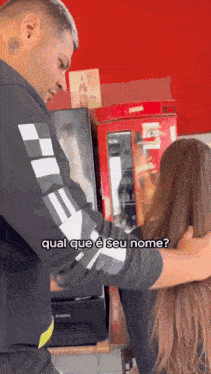 a man is holding a woman 's hair in front of a refrigerator that says " qual que e seu nome "