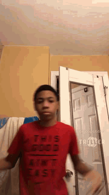 a boy in a red shirt that says this is good aint easy