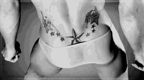 a black and white photo of a man 's back with a star tattoo on it