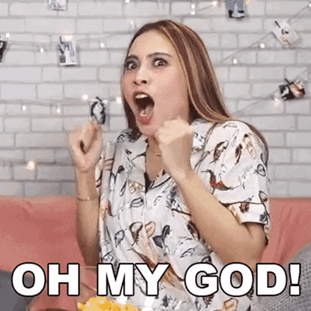 a woman is sitting on a couch eating french fries and making a funny face .