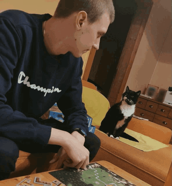 a man wearing a champion sweatshirt is playing a game