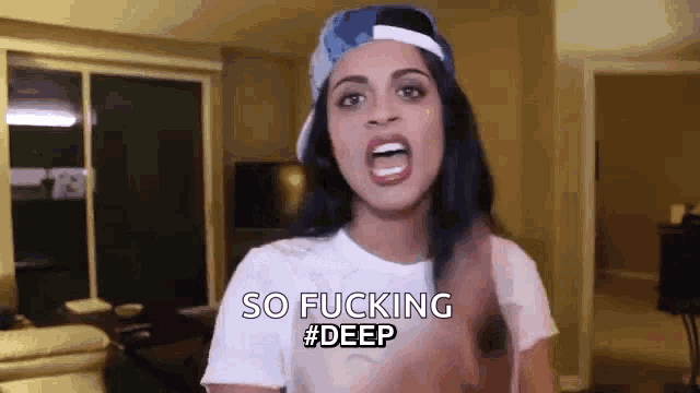 a woman wearing a hat and a white t-shirt is making a funny face and saying `` so fucking deep ''