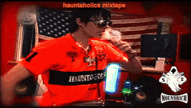a man wearing an orange shirt that says hauntholics on it