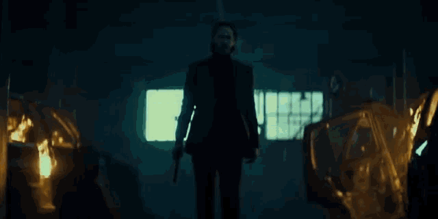 a man in a suit is holding a gun in his hand