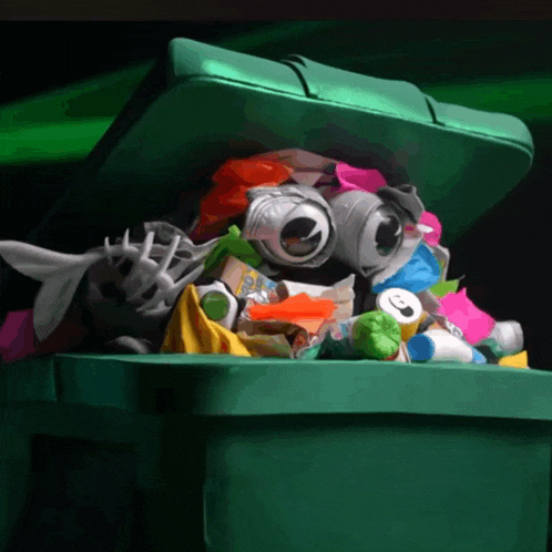 a green trash can filled with lots of garbage including a can that has the number 3 on it