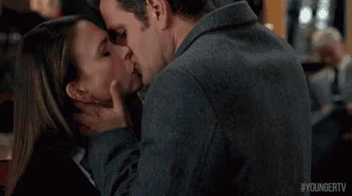 a man is touching a woman 's neck while they are kissing .