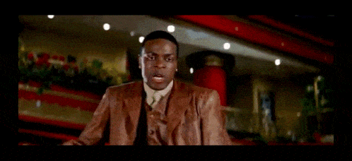 a man in a brown suit is holding a stack of money and says but you one crazy-ass bitch