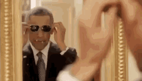 barack obama is wearing sunglasses and smoking a cigarette while looking at himself in the mirror .