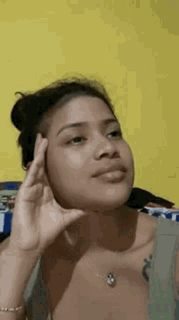 a young woman is making a funny face while sitting on a bed .