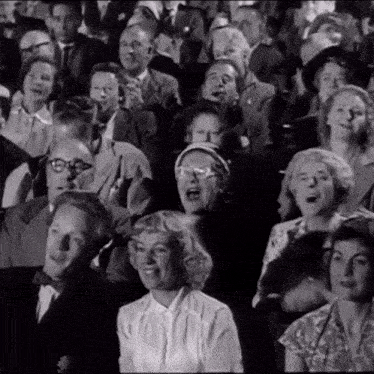 a black and white photo of a crowd of people sitting in a stadium
