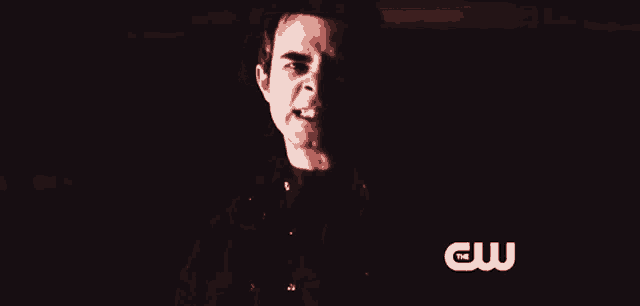 a close up of a man 's face with a cw logo on the bottom