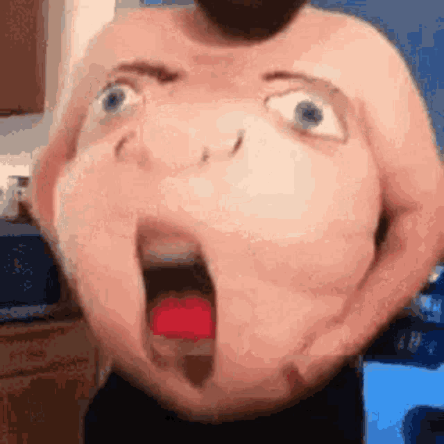 a shirtless man with a cartoon face on his belly is making a funny face .