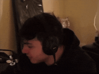 a man wearing headphones is sitting in front of a microphone .