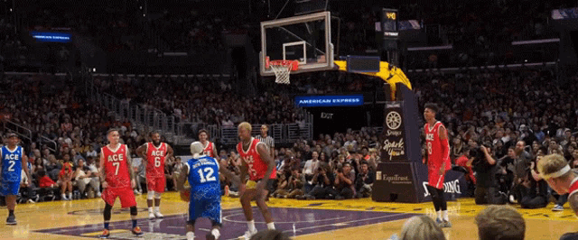 a basketball game is being played in front of a crowd with a sign that says american express