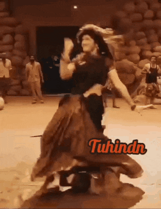 a woman is dancing in front of a sign that says ' tuhindn '