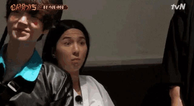 a man and a woman are sitting in front of a tv screen that says ' tvn ' on it