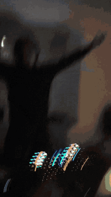 a blurry picture of a person with their arms outstretched in a dark room