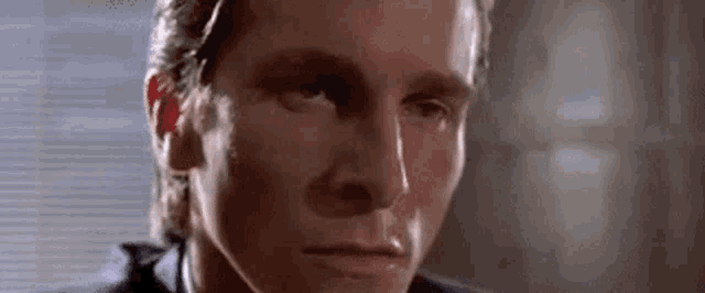 a close up of a man 's face in a suit and tie looking at the camera .