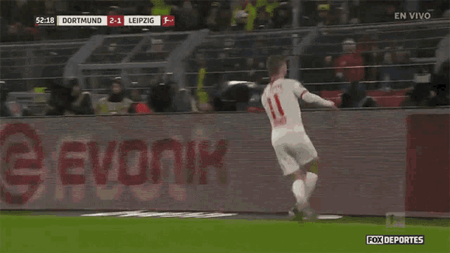 a soccer player with the number 11 on his jersey runs on the field
