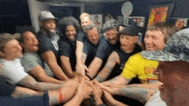 a group of men put their hands together in a huddle