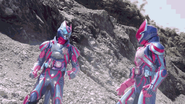 two kamen riders standing next to each other on a rocky hillside .