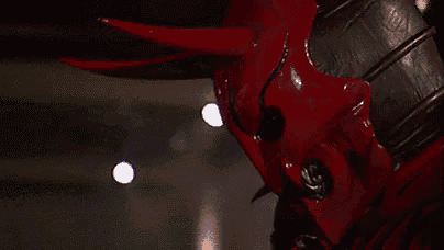a close up of a person wearing a red devil costume with horns and teeth .