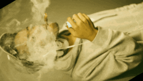 a man is smoking a cigarette while laying down
