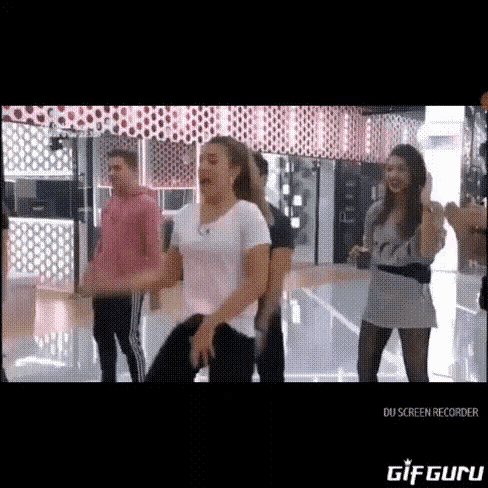 a group of people are dancing together in a gym .